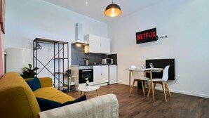 Ein moderner Wohnraum mit Sofa, Esstisch und Küchenbereich.