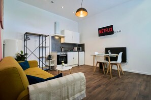 Ein moderner Wohnraum mit Sofa, Esstisch und Küchenbereich.