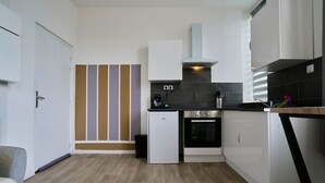 A compact kitchen with a refrigerator, oven, and a small countertop. - En D Placement 5 Calme et Lumineux (Tourcoing)