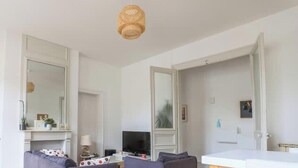 Un salon moderne comprenant un canapé, un téléviseur et une table à manger.