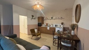 A compact living space with a dining area, kitchenette, and a sofa. - Le Citadin Appartement Arras Centre 6 Personnes (Arras)