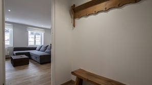 A living room with a sofa, a wooden bench, and a wall-mounted shelf. - Le Perchoir de Maurice Calme et Cosy (Arras)