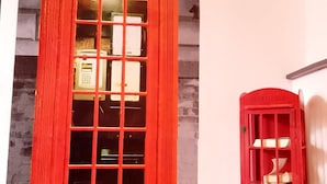 Una cabina telefónica roja con un letrero que dice 'TELEPHONE' y una cabina más pequeña con un diseño parecido.