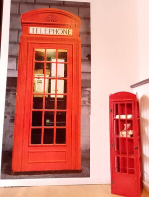 A red telephone booth with a sign that reads 'TELEPHONE' and a smaller booth with a similar design. - Le British Lensois Wifi Bollaert 4pers (Lens)