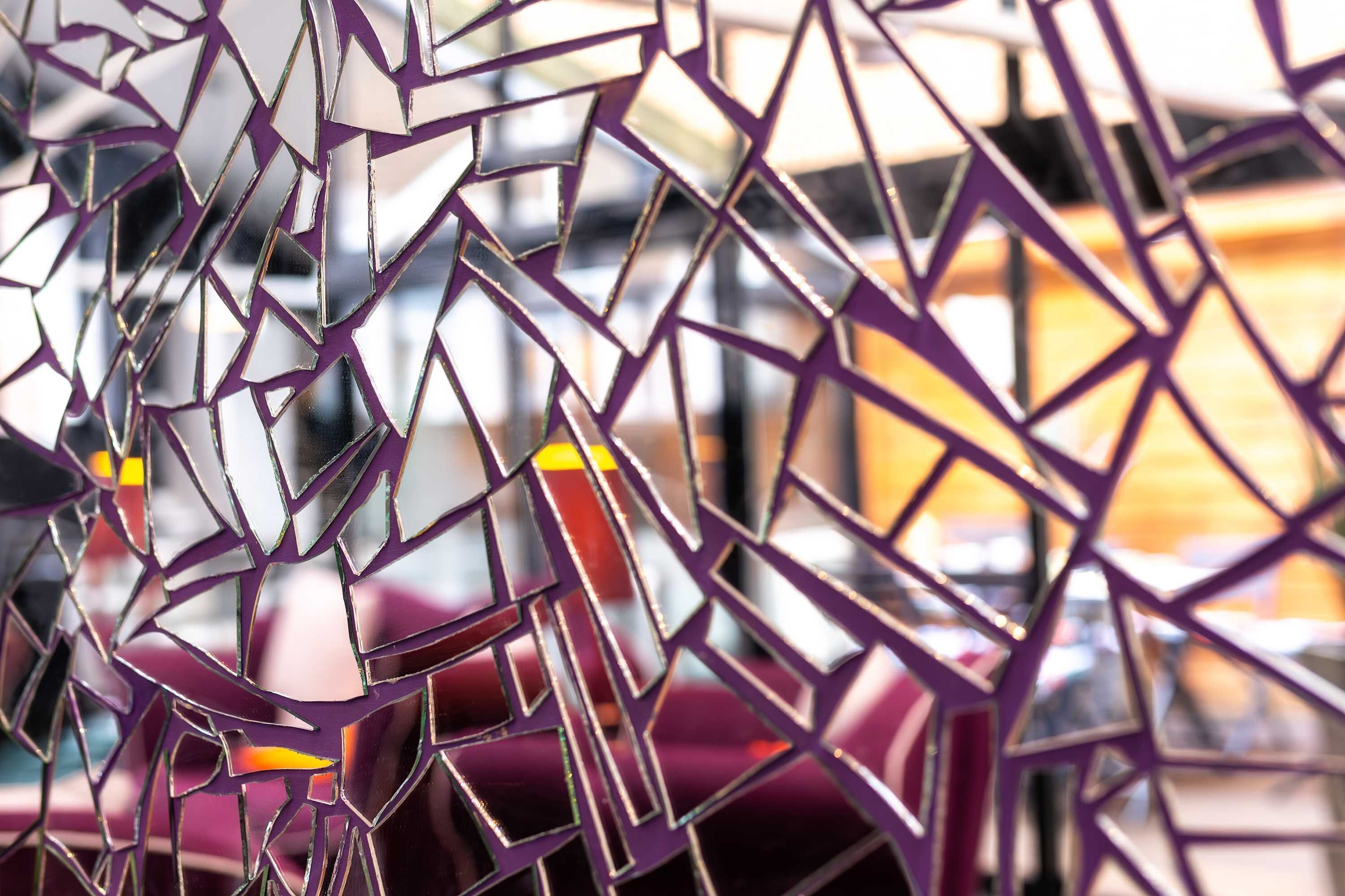 A close-up of a geometric, purple-patterned structure, possibly part of a building's facade or interior design.