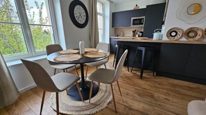Una cocina moderna con una mesa de comedor redonda, sillas y vistas al exterior.