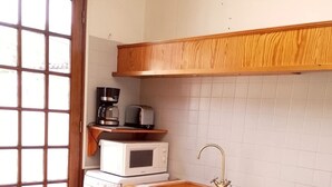 A kitchen with a wooden table, a microwave, a coffee maker, and a sink. - Le G te des Pr s Terrasse Parking Gratuit 5pers (Lievin)