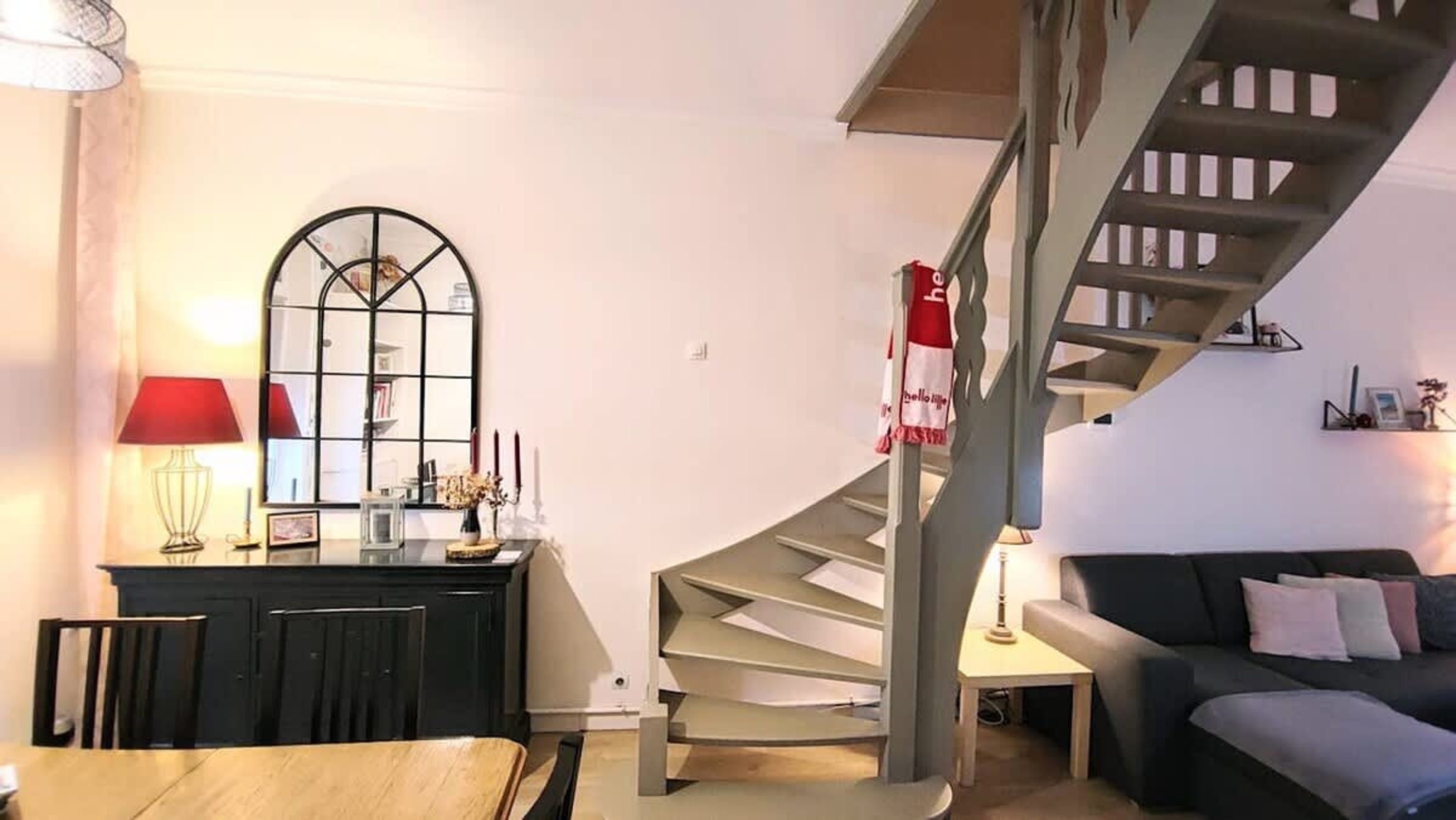 Una sala moderna con comedor, una escalera y vistas al exterior.