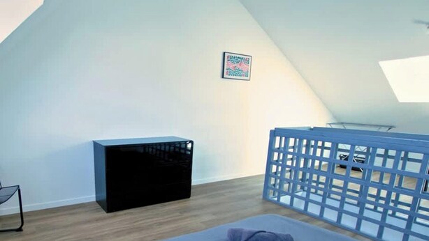 A bedroom with a bed, a black storage unit, a blue crib, and a framed picture on the wall. - Chez Jean 2 Hyper Centre Wifi 2 Pers Bollaert (Lens)