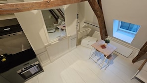 Una cocina con armarios blancos, una mesa de madera y una ventana con vistas.