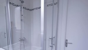 A modern bathroom with a glass-enclosed shower, a white sink, and a door with a handle. - Chez Jean Hyper Centre 4 Chambres Wifi 8 Pers (Lens)