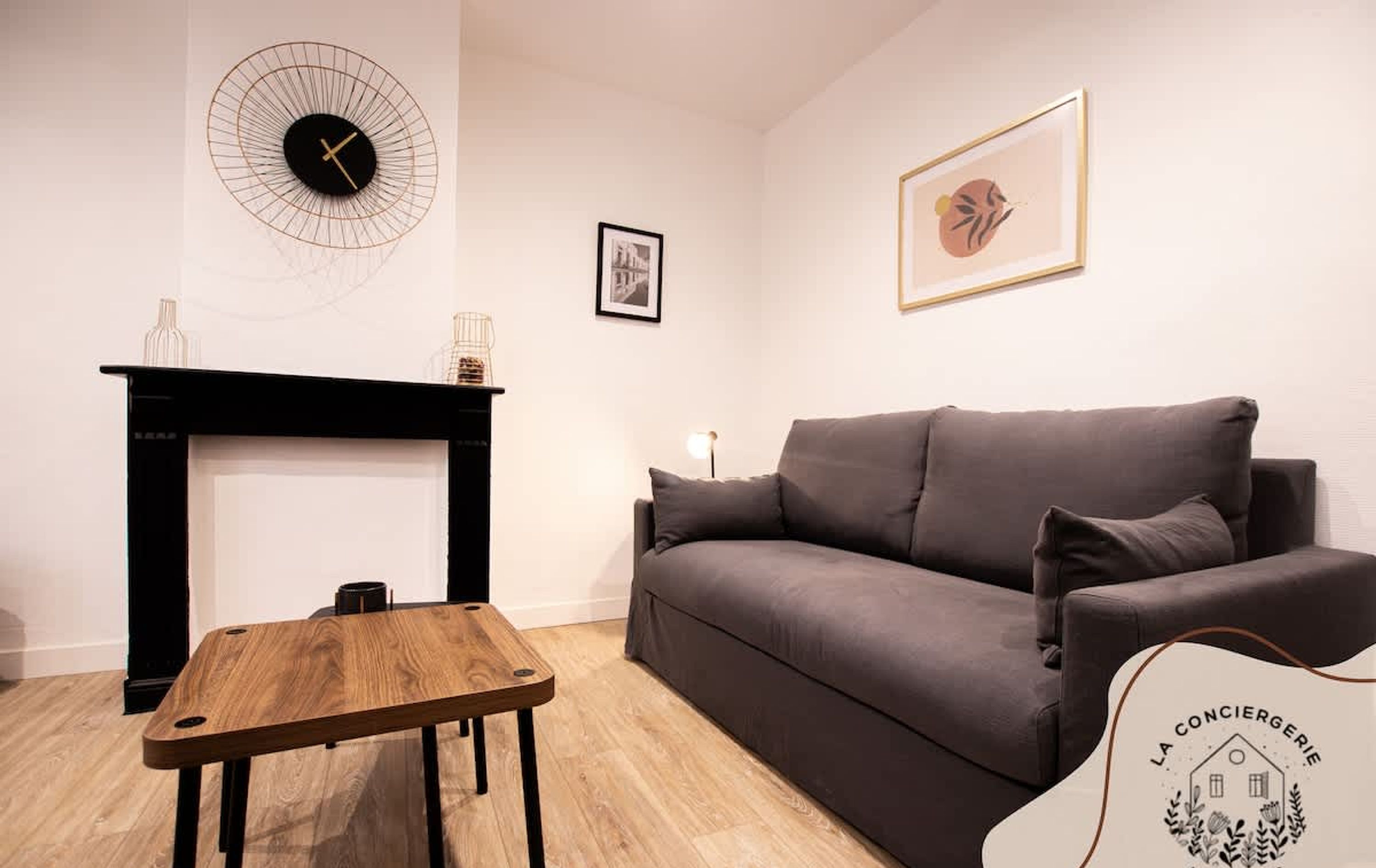 Una sala de estar con chimenea, un sofá, una mesa de centro y un reloj de pared.
