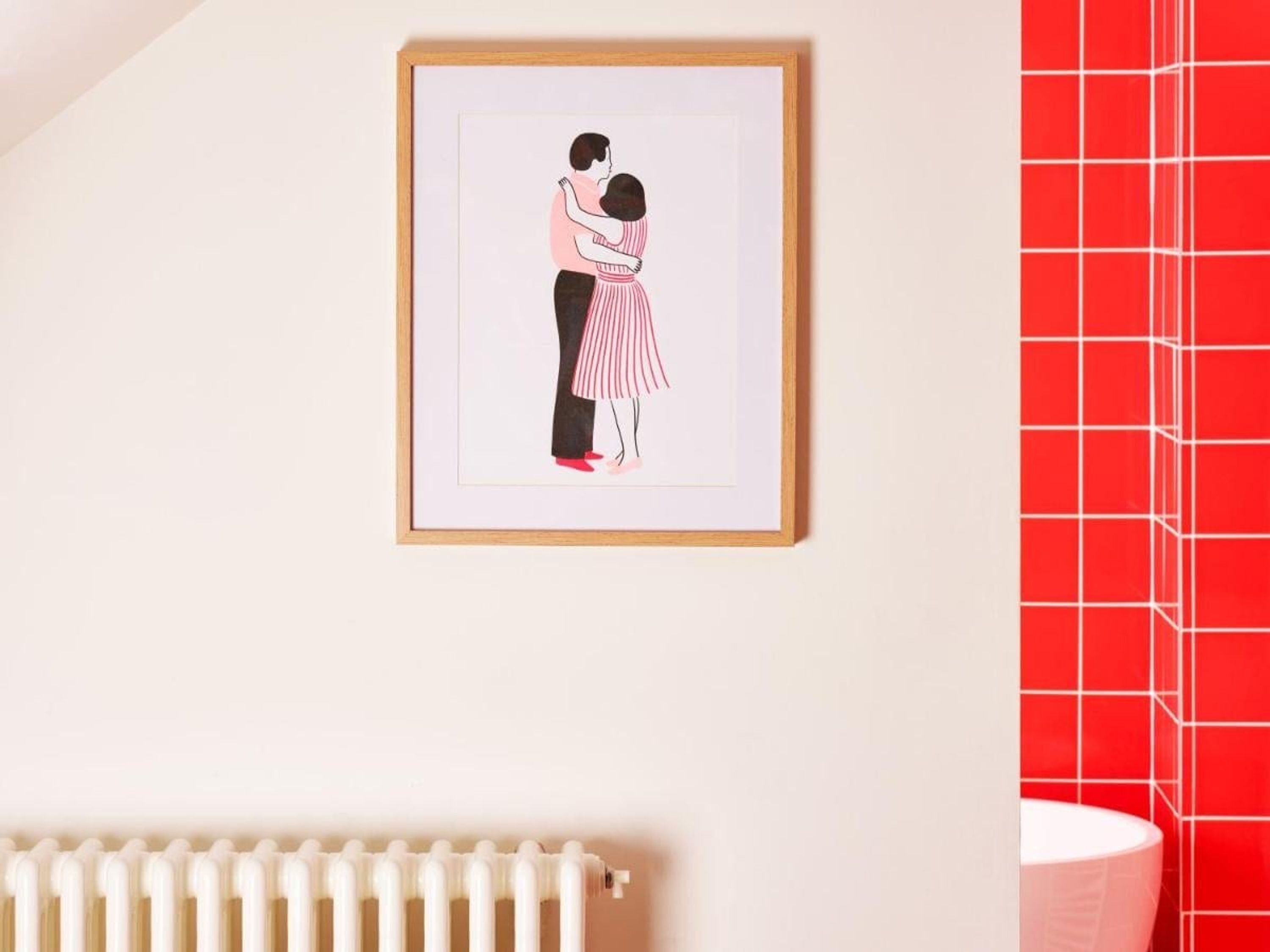 A framed illustration of a couple embracing on a wall.