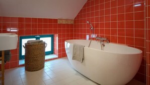 A modern bathroom with a freestanding bathtub, a wicker basket, and a window with a view. - Chez Marie Jeanne -La Cite des Electriciens- 2pers (Bruay-la-Buissiere)