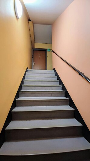 A staircase with a handrail, leading to a door at the top. - Atelier Wagram Au Coeur de Troucoing (Tourcoing)