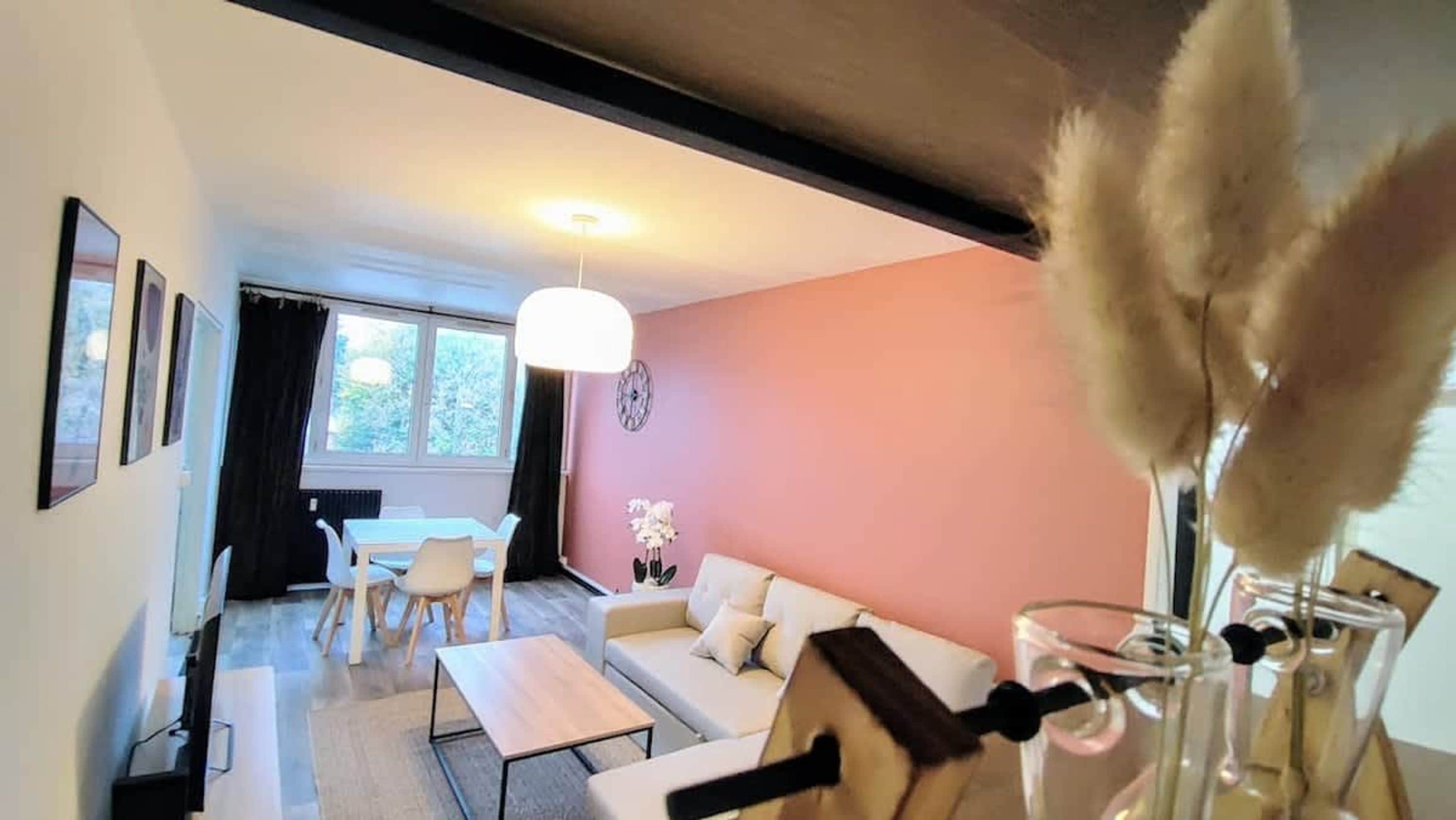 A living room with a sofa, coffee table, and a dining area with chairs.