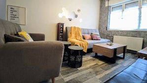 Sala de estar com sofá, mesa de centro, luminária e luminária de parede.