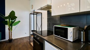 Una cocina moderna con microondas, estufa y una planta en maceta.