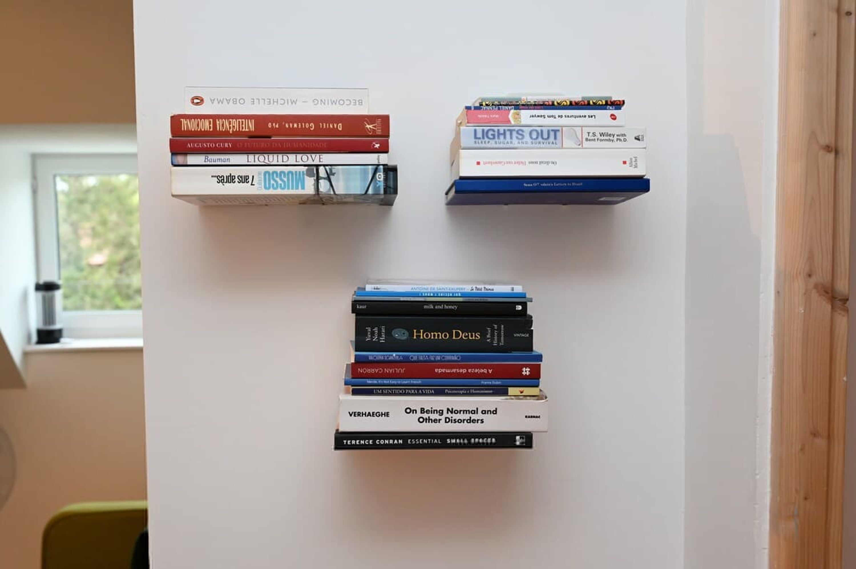 Een muur met drie stapels boeken.
