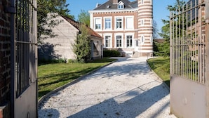 A gated driveway leading to a large, historic building with a prominent tower and a smaller attached structure. - Geantgw Principale Appt Appartement Confort - Propri t Art et Histoire (Aire-sur-la-Lys)