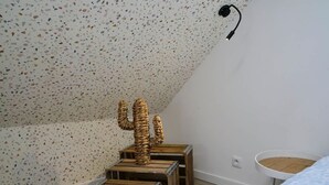 A room with a speckled ceiling, a wooden cactus sculpture, and a round wicker basket on a white wall. - En d Placement 9 Dernier Tage Wifi Gratuit (Tourcoing)