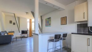 Een modern appartement met keuken, eethoek en woonkamer.