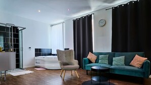 A modern living room with a sofa, armchair, and a round coffee table. - Grand Studio Avec Balneo Proche Gare (Tourcoing)