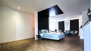 A modern bedroom with a bed, a sofa, and a dining area. - Grand Studio Avec Balneo Proche Gare (Tourcoing)