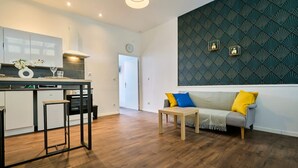 Una cocina moderna con comedor, un sofá con cojines y una pared con diseño.