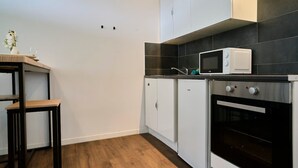 Una cocina con armarios blancos, microondas y horno.