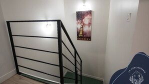 Una escalera con barandilla de metal negro, un cartel de un edificio con fuegos artificiales y un logotipo en la pared.