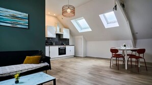 Een modern loft appartement met een eethoek, keuken en een groot raam.