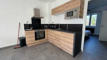 A modern kitchen with a microwave, oven, and sink.