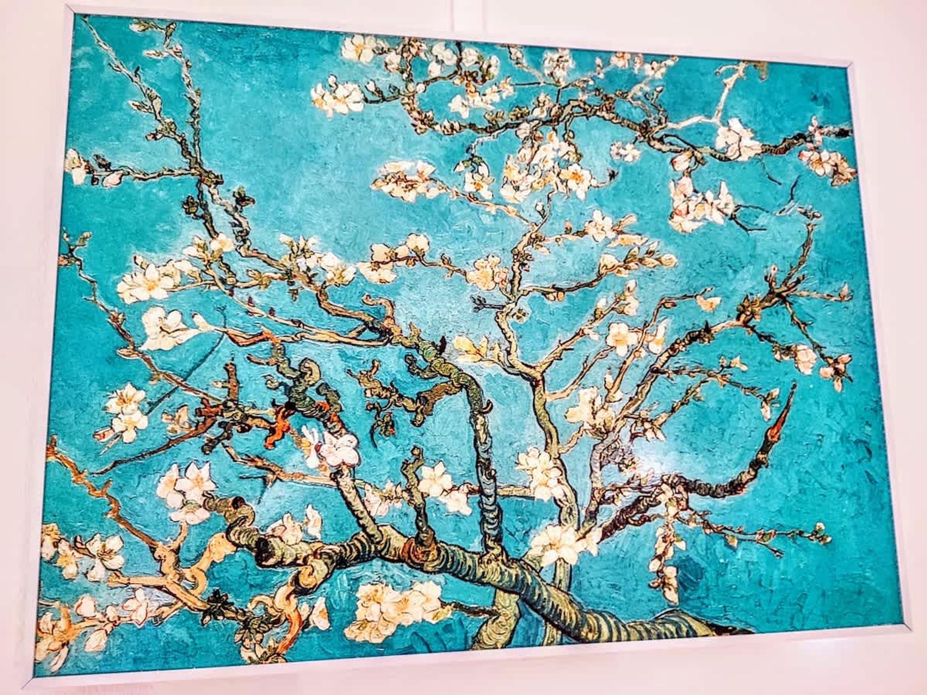 Une peinture représentant un arbre avec des branches et des fleurs.