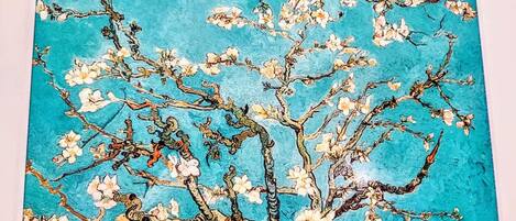 Une peinture représentant un arbre avec des branches et des fleurs.