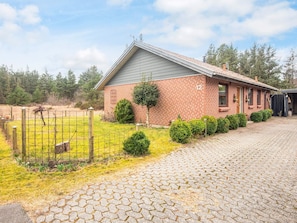 A brick building with a grey roof, a paved driveway, and a fenced yard. - 4 Person Holiday Home in Norre Nebel (Norre Nebel)
