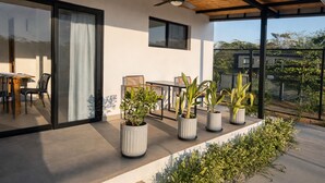 A covered patio area with a dining table and chairs, potted plants, and a view of the surrounding area. - Villa 3 bedrooms / 3 bathrooms • Private swimming pool - Tamarindo (Tamarindo)