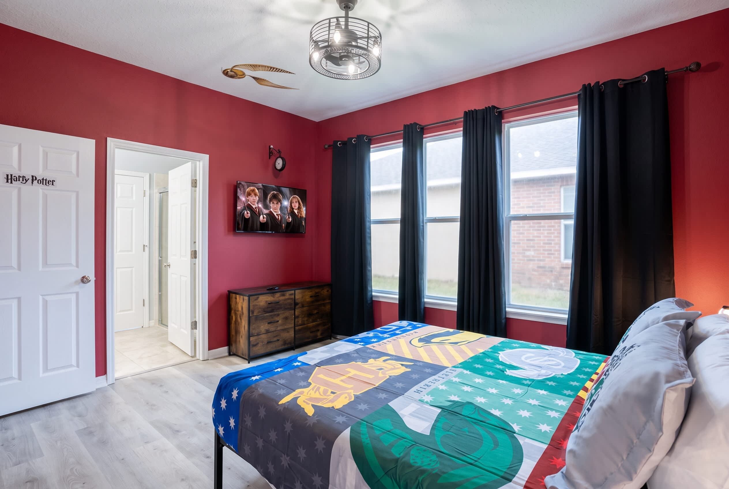 A bedroom with a bed, a dresser, a TV, and a door labeled 'Harry Potter'.