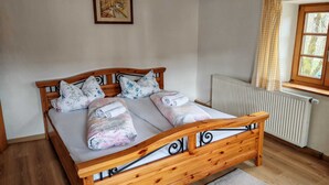 Een houten bed met hoofdeinde, twee kussens en een dekbed.