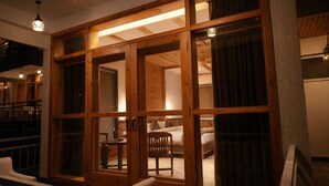 Une pièce dotée de portes coulissantes en bois, d’un lit, d’une chaise et d’une petite table.