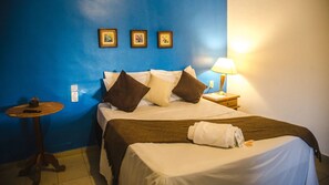 A hotel room with a bed, a bedside table, a lamp, and three framed pictures on the wall. - Pousada Recanto (Santana do Riacho)