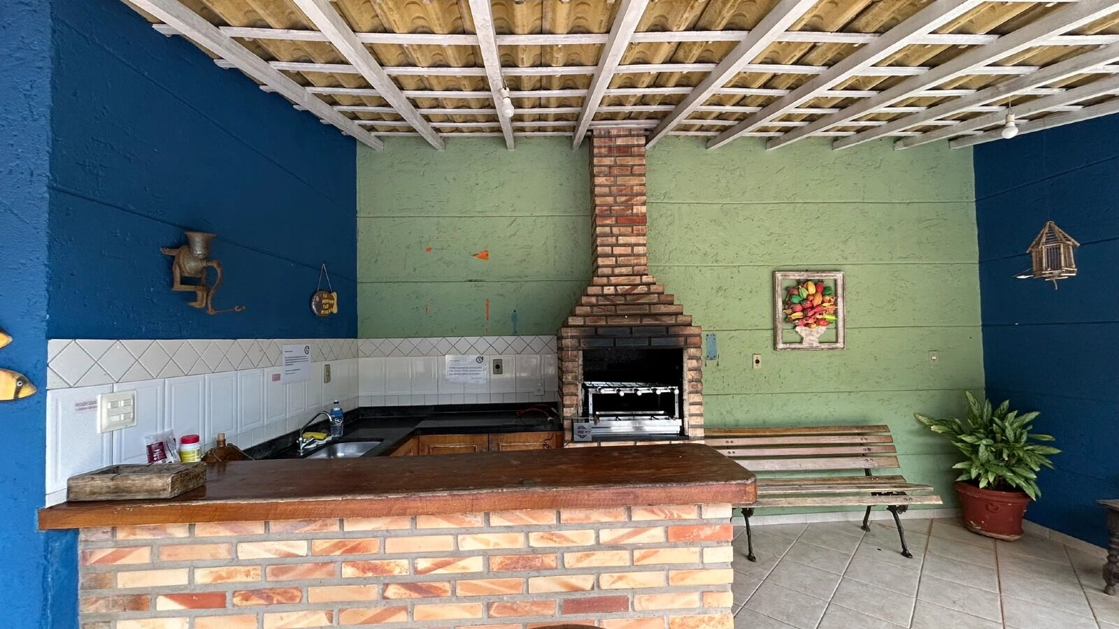 A kitchen with a brick oven, a sink, and a bench.