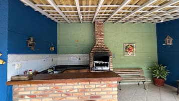 A kitchen with a brick oven, a sink, and a bench.