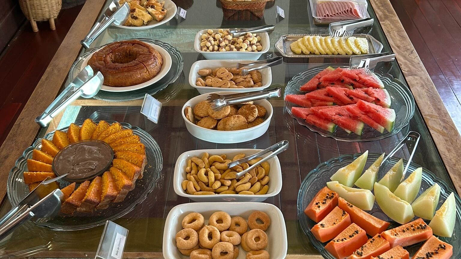 A buffet with various food items including a cake, nuts, fruits, and pastries.
