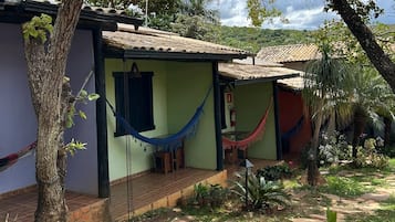 Una casa con techo de tejas, una hamaca y un pequeño jardín.
