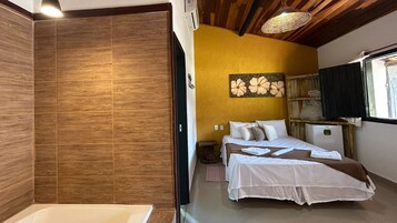 Un dormitorio con cama, mesita de noche, una obra de arte en la pared y ventana con persianas.