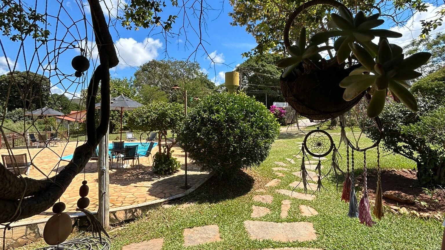 Un jardin avec un chemin de pierre, une piscine et du mobilier d’extérieur.