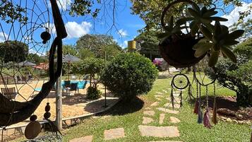 Un jardin avec un chemin de pierre, une piscine et du mobilier d’extérieur.