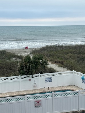 Blick auf einen Strand mit Poolbereich, einem Schild mit der Aufschrift 'No Diving Allowed' und einem Schild für eine Abschleppzone.