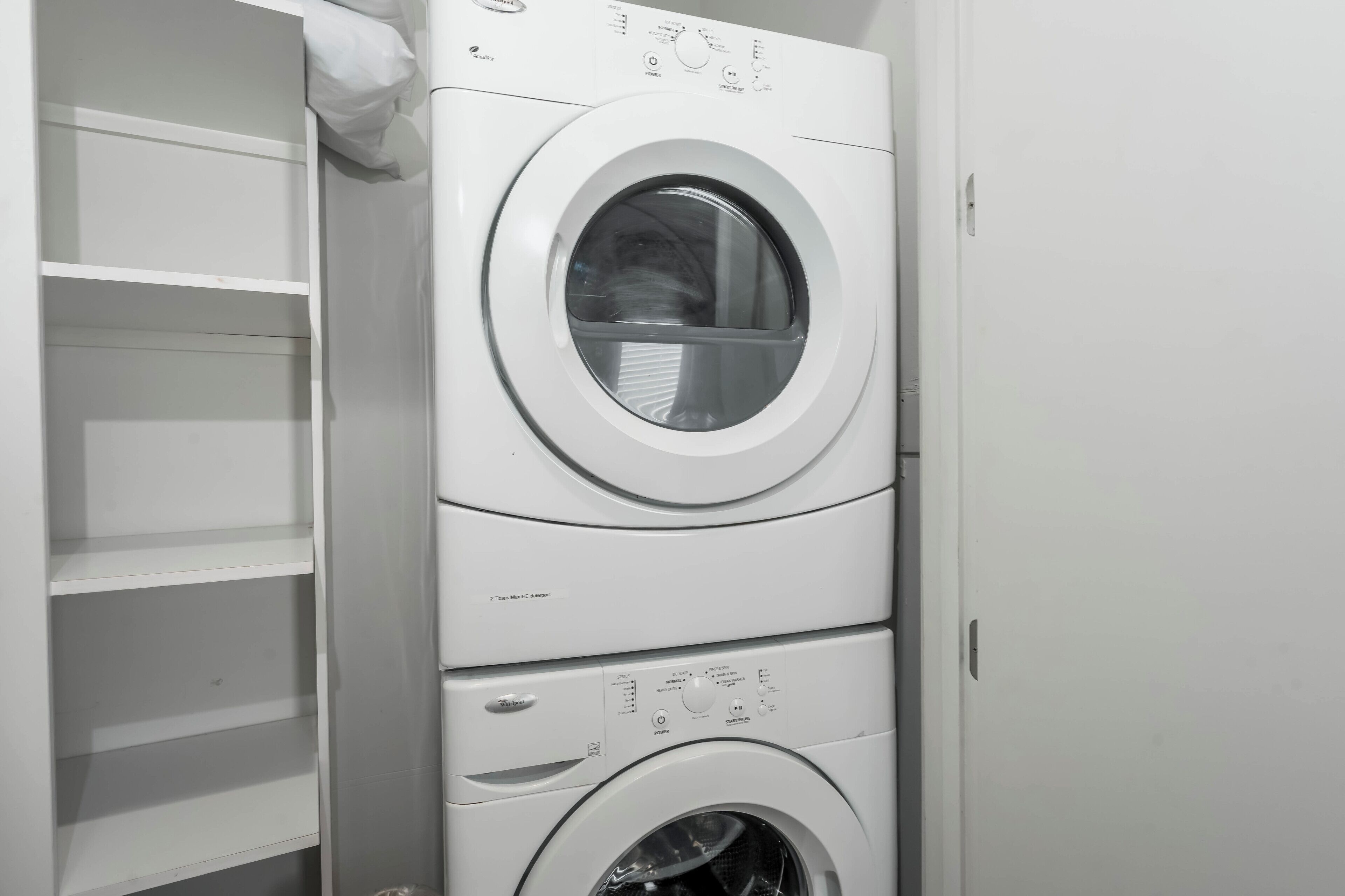 A stacked washer and dryer unit with control panels and a door.